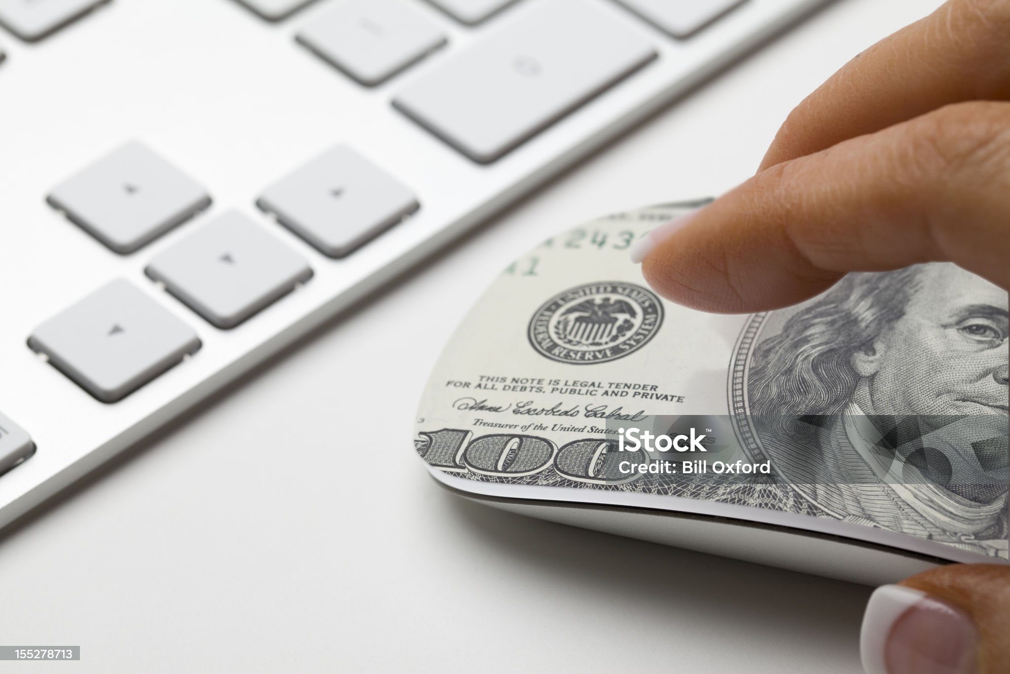 Hand on mouse with 100 dollar bill on it. Concept for affiliate marketing or e-commerce.